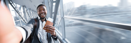 Happy African American Businessman Taking Selfie In Airport, Holding Passportの写真素材