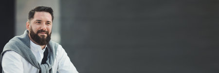 Friendly stylish businessman standing outdoors, copy spaceの写真素材