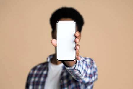 Guy demonstrating blank screen of smartphone, copy spaceの写真素材