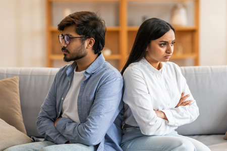 Young Couple Having Argument While Sitting On Couch At Homeの写真素材