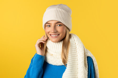Woman Wearing White Hat and Scarf Isolated on Yellowの写真素材