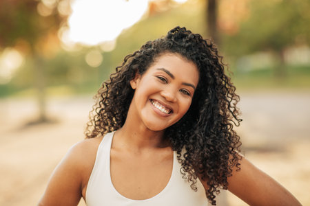 Smiling Athletic Woman With Curly Hair Have Workout Outdoorsの写真素材