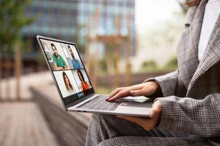Business Professional Participating in Morning Outdoor Virtual Meeting on Laptopの写真素材
