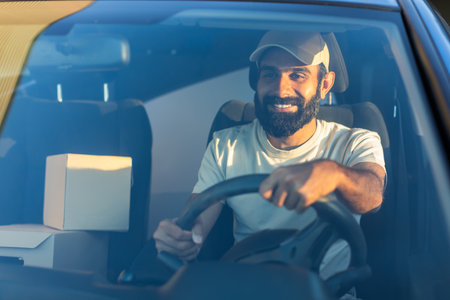 Smiling Delivery Driver Navigates Urban Streets in the Early Morning