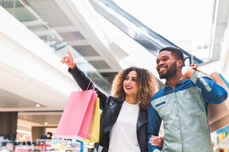 Young african couple doing shopping together in city mallの写真素材
