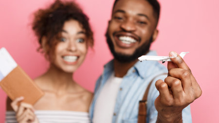 Joyful Couple Holding Passport and Toy Airplaneの写真素材