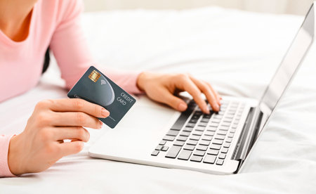 Cropped of Lady Shopping Online Using Laptop and Credit Cardの写真素材