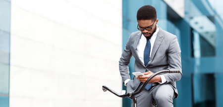 Professional African American man on phone riding bicycleの写真素材