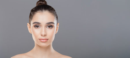 Woman With Bun Hairstyle Posing Topless on Grayの写真素材