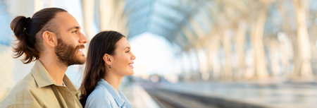 Smiling millennial european couple look at train station or airportの写真素材