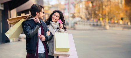 Couple Walking Down Street With Shopping Bagsの写真素材