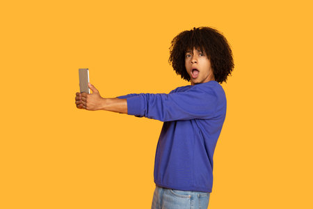 Surprised Man Taking Selfie With Tablet Against Yellow Background