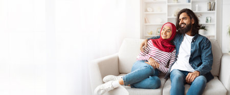 Happy Couple Relaxing On White Sofa In Their Living Roomの写真素材