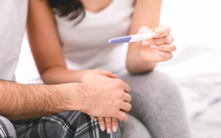 Woman Showing Pregnancy Test to Partner in Bed, Croppedの写真素材
