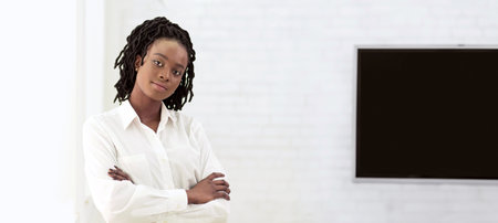 African American businesswoman in professional attire standing in modern office