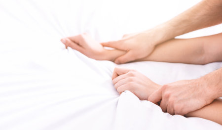 Closeup of Hands Holding and Touching on White Beddingの写真素材