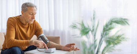 Senior Man Checking Blood Pressure at Home During the Day