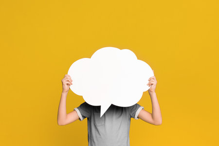 Little boy holding an empty speech bubble in front of his head