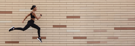 Athletic Young Woman In Sportswear Running Over Brick Wall Background