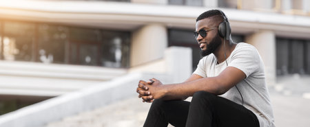 Man Listening to Music With Headphones in Urban Settingの写真素材