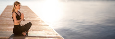 Peaceful middle aged woman meditating in lotus position outdoorsの写真素材