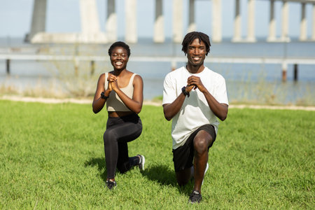 Couple Performing Lunges Together on Green Grass by the Water