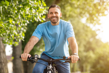 Happy Man Riding Bicycle On Sunny Summer Day In Park