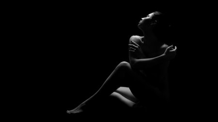 Woman Sitting In Darkness With Arms Crossed, Copy Spaceの写真素材