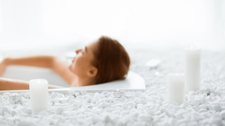 Total relaxation. Woman enjoying hot bath with candles