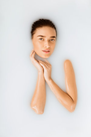 Spa and skincare concept. Sexy girl enjoying milk bath, top view