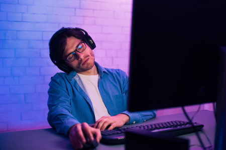 Tired Gamer Working Late at Night in Front of Computerの写真素材