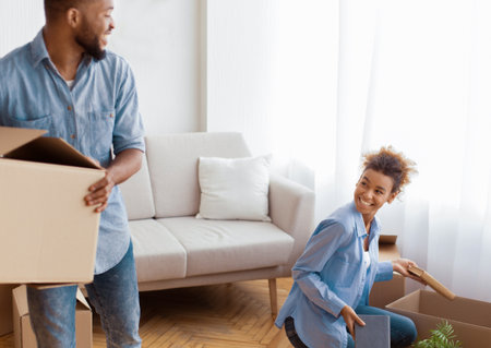 African American Spouses Packing Moving Boxes Indoorの写真素材