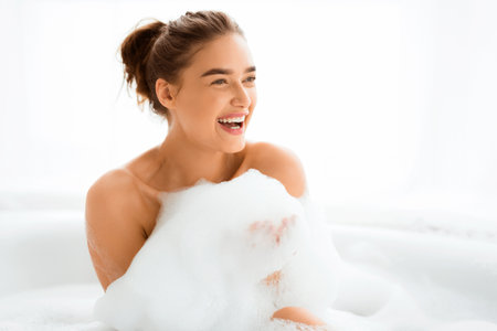 Beautiful woman taking relaxing bath with foamの写真素材