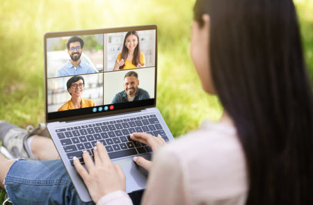 Woman on Laptop Video Chatting With Friends Outdoorsの写真素材