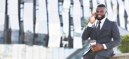 Businessman Talking On Phone Having Coffee Break Sitting Outdoorsの写真素材
