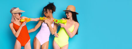 Three Women In Swimsuits With Water Guns On Blue Background