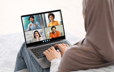Woman Using Laptop To Video Chat With Friends During Day