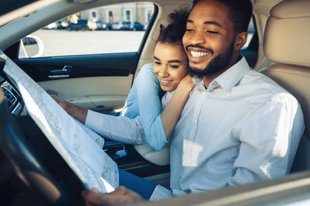 Couple In A Car Looking At A Map While Driving