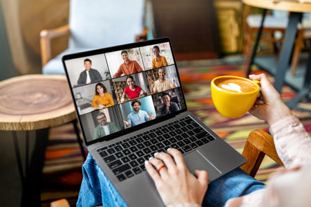 Person Attending Video Conference With Multiple Participants in a Cafe