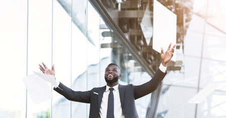 African American Man Throwing Papers In The Air In Cityの写真素材