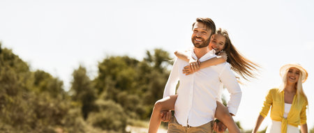 Father playing with daughter, walking in natureの写真素材