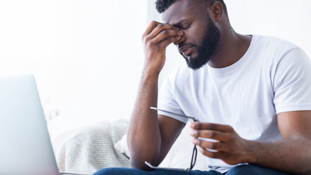 Man Experiencing Eye Strain While Working On Laptopの写真素材