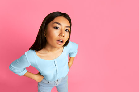 Young Woman Posing on Pink Studio Background