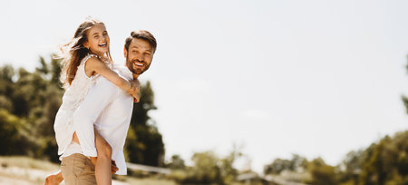 Happy Family Enjoying Summer Day Together, Father Carrying Daughter Outdoorsの写真素材