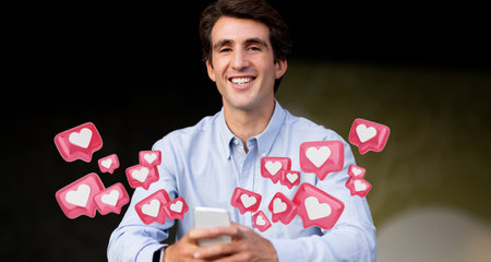 Man Smiling While Holding Smartphone Surrounded by Heart Iconsの写真素材