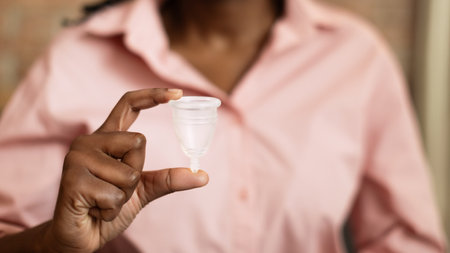 Closeup of a Womans Hand Holding a Menstrual Cupの写真素材
