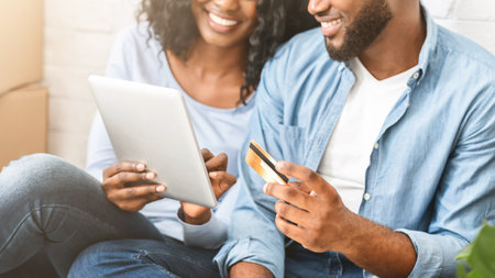 Close up of couple purchasing furniture online, using digital tabletの写真素材