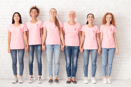 Diverse Breast Cancer Volunteers Ladies Holding Hands Standing Together Indoorsの写真素材