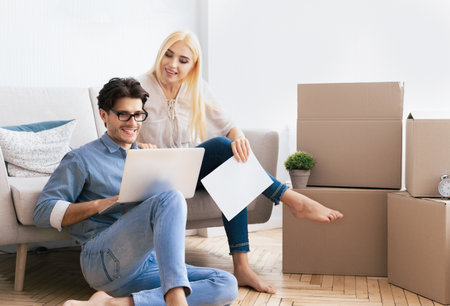 Couple Using Laptop In New Apartment