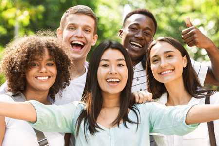 Group of multi-ethnic teen friends taking selfie picture outdoorsの写真素材